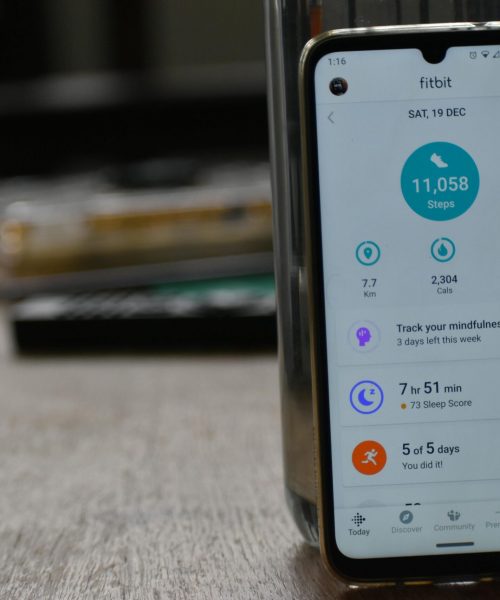 Close-up of a smartphone displaying a fitness tracking app with health statistics.