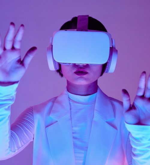 Woman in white long sleeves using virtual reality headset in a conceptual studio shoot.